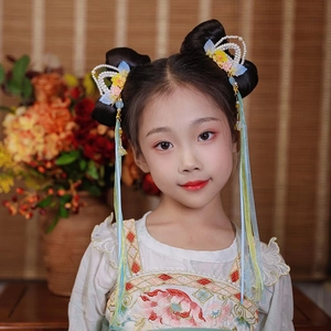 Detailed view of traditional Chinese hair clips with pearls and silk tassel on a young girl