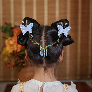Vue détaillée des épingles à cheveux papillon bleu avec glands dorés pour filles