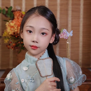 Detail of traditional Chinese hair pin with pink flower, blue butterfly and gold tassels