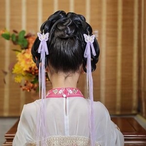 Detail view of purple embroidery butterfly hair clips with tassels and silk ribbons
