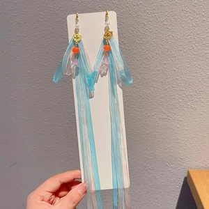 Close-up of long tassels ancient style earrings with blue and pink gauze and gold clouds