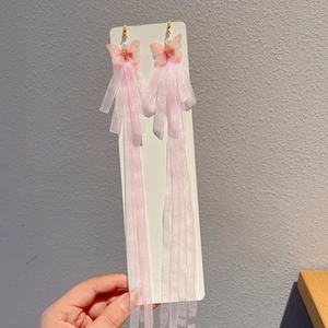 Detail of pink butterfly earrings with long tulle tassels and white pearls for girls