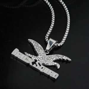 Macro shot of silver hip-hop eagle pendant with crystal inlay and Brick Squad lettering