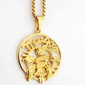 Macro view of gold round eagle pendant with mangas text and cutout bird detail