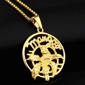 Macro detail of golden eagle pendant with Monaco engraving on a black leather background
