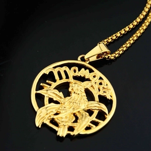 Macro shot of gold-plated eagle pendant necklace with hollowed details on black background
