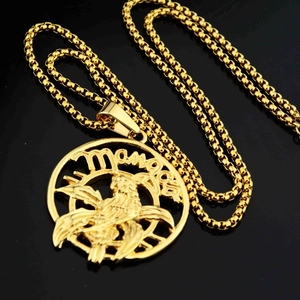 Detailed macro of gold eagle round pendant with MARCOS engraving on box chain necklace