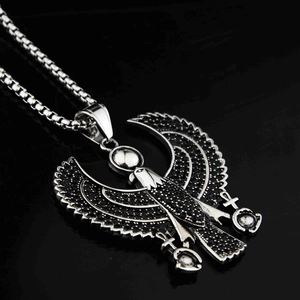 Gros plan du pendentif aigle Horus égyptien avec pierres noires et chaîne box