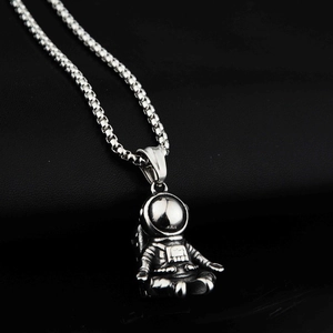 Detail view of astronaut pendant on box chain with oxidized silver finish and textures