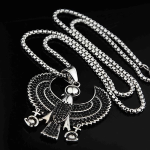 Détail du pendentif aigle Horus serti de strass noirs et croix Ankh sur une chaîne box