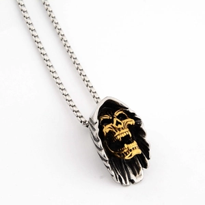 Macro détaillée d'un pendentif crâne doré gothique avec cape argentée sur chaîne box inox