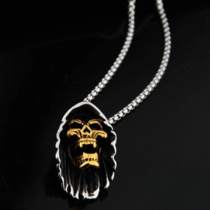Pendentif tête de mort gothique avec capuche argentée et crâne doré sur fond noir