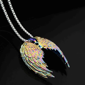Détail macro du pendentif aile d'ange irisé avec chaîne box sur une surface noire