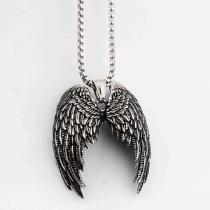 Gros plan détaillé du pendentif aile d'ange argent rétro avec texture de plumes et chaîne