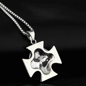 Vue détaillée du pendentif croix pirate argentée avec texture et chaîne à maillons box