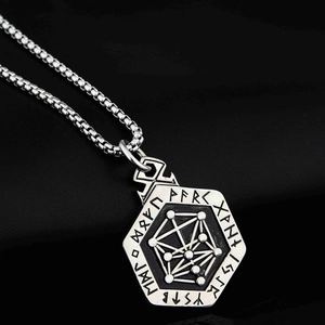 Macro detail of Nordic Viking runes and geometric totem engraved on steel pendant