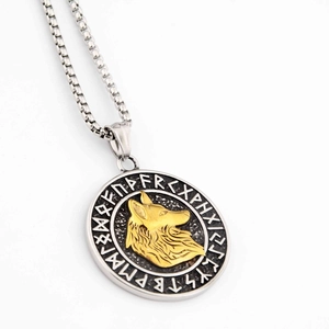 Détail du pendentif rond avec tête de loup dorée et gravures de runes nordiques anciennes