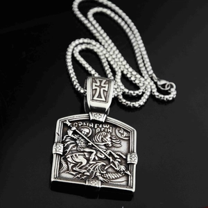 Détail macro du pendentif Saint Georges avec relief sur une chaîne serpent élégante