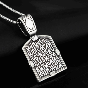 Détail macro du pendentif de chevalier en argent avec écritures et motifs de croix