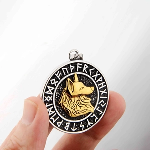 Gros plan du pendentif tête de loup viking avec relief doré et gravures de runes nordiques