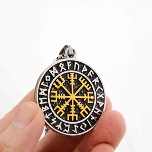 Detail of Viking compass pendant with gold Vegvisir symbol and rune engravings