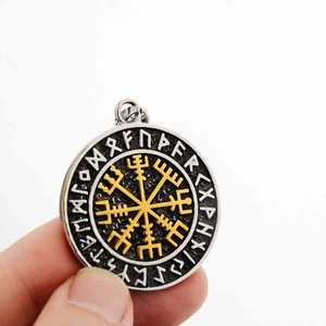 Macro detail of Viking Vegvisir compass pendant with silver runes and golden center