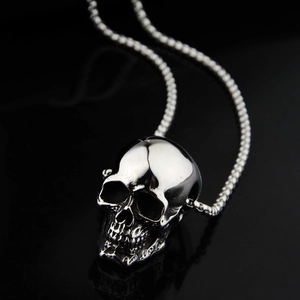 Polished stainless steel skull pendant necklace with high-gloss finish on black background