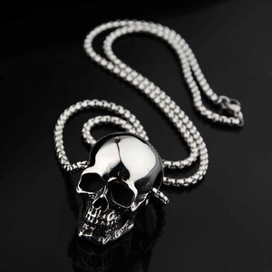 Polished skull pendant on a chunky ring chain with gothic punk style over reflection