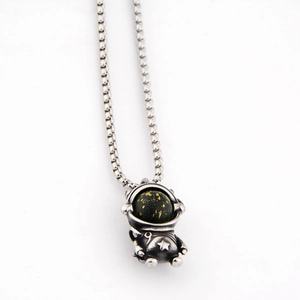 Vue détaillée du pendentif astronaute avec casque effet galaxie et motifs étoiles