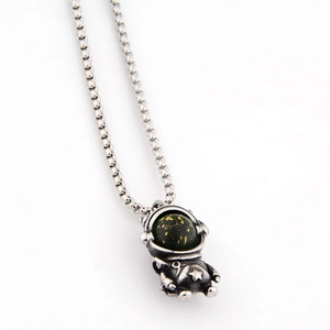 Gros plan du pendentif astronaute en argent avec sphère étoilée et chaîne vénitienne
