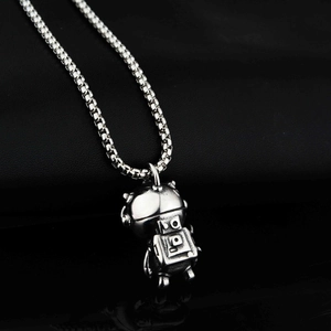 Détail macro du pendentif astronaute 3D avec finition vintage sur chaîne en acier