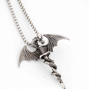 Macro detail of dragon wrapped around a sword pendant in vintage silver style necklace