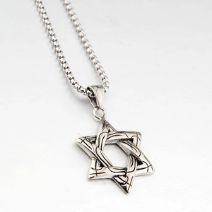 Gros plan du pendentif étoile hexagramme argenté avec texture tissée sur chaîne acier