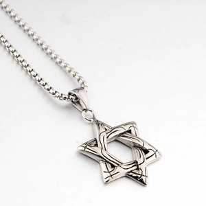 Détail macro du pendentif étoile hexagramme argenté avec texture tissée sur chaîne
