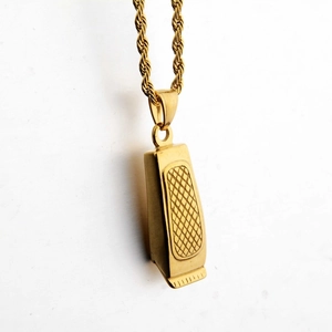 Macro shot of a golden clipper pendant featuring textured details and a rope chain necklace