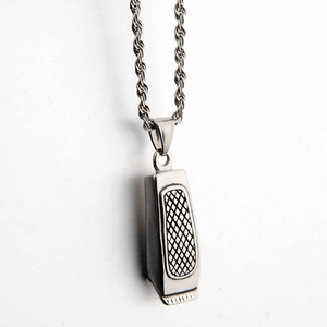 Macro shot of silver stainless steel hair clipper pendant on a twisted rope chain necklace