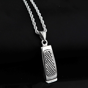 Detail of silver barber clipper pendant with textured finish on a stainless steel rope chain