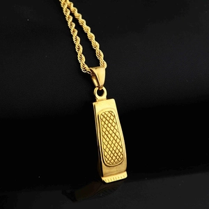 Macro view of gold barber clipper pendant with detailed mesh texture and rope chain