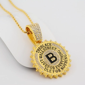 Macro shot of gold hip hop pendant with rhinestones and black letter B on rope chain