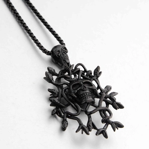 Dettaglio macro del ciondolo teschio Medusa nero opaco con serpenti e catena a sfere