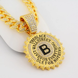 Hip hop gold Cuban chain necklace with a large iced-out B letter pendant on white stand