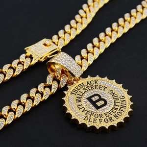 Detailed close-up of golden iced-out Cuban chain necklace with a large B-letter pendant