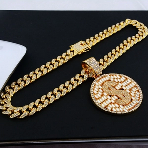 Macro detail of iced out gold dollar sign pendant with full zircon on Cuban link chain