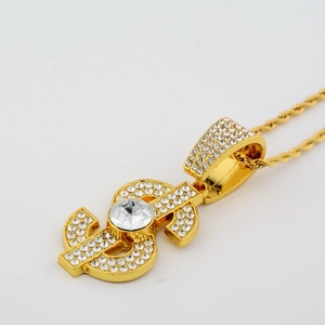 Close-up of golden dollar sign pendant with sparkling pavé crystals and rope chain link