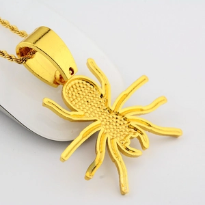 Détail d'un pendentif araignée plaqué or avec texture et chaîne de type corde