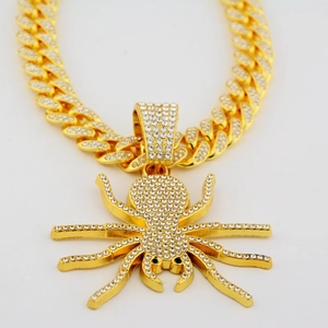 Gros plan sur la chaîne cubaine hip hop dorée avec pendentif araignée serti de strass blancs