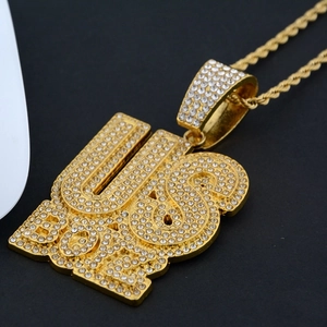 Macro shot of gold-plated US BOSS pendant with cubic zirconia and a heavy rope chain