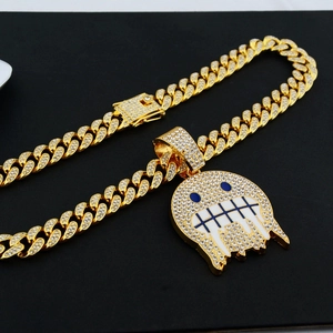 Détail d'une chaîne cubaine dorée avec un pendentif fantôme hip hop glacé