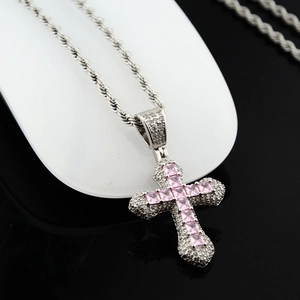 Détail d'une chaîne corde argentée avec pendentif croix et zircons carrés roses