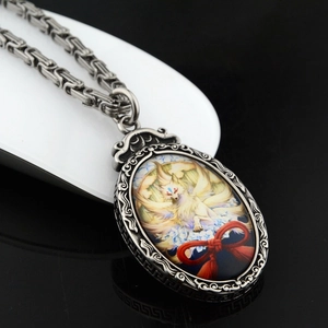 Detail eines antiken Silberanhängers mit Koi-Motiv und Fuchsgrafik an einer Metallkette